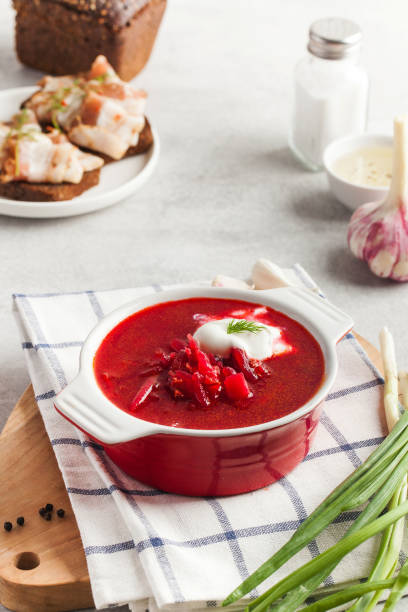 istock Delicious fresh red borscht, dark bread with lard and salt on kitchen table. 1326019687