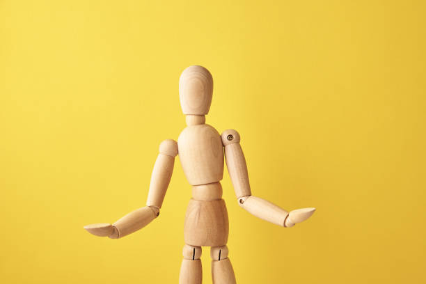 istock Wooden doll on yellow background 1326023489
