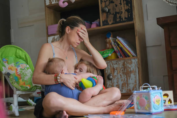 istock Tired Mother Tandem Nursing Her Two Children 1326023627