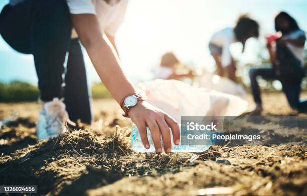 Shot Of An Unrecognisable Teenager Picking Up Litter Off A Field At Summer Camp Stock Photo - Download Image Now