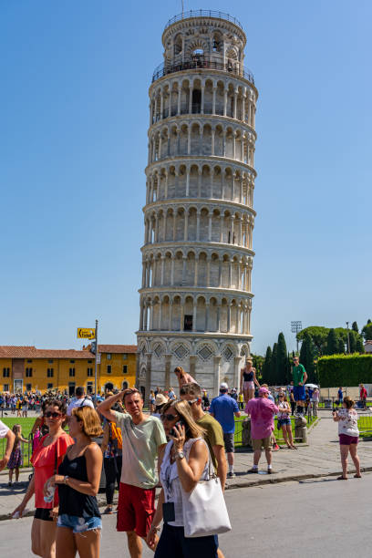 foto vertical de turistas visitando la torre inclinada de pisa en italia - leaning tower of pisa people crowd tourism fotografías e imágenes de stock