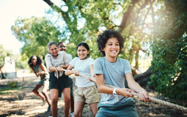 plan d’un groupe d’adolescents jouant à un jeu de tir à la guerre au camp d’été - teenager team carefree relaxation photos et images de collection