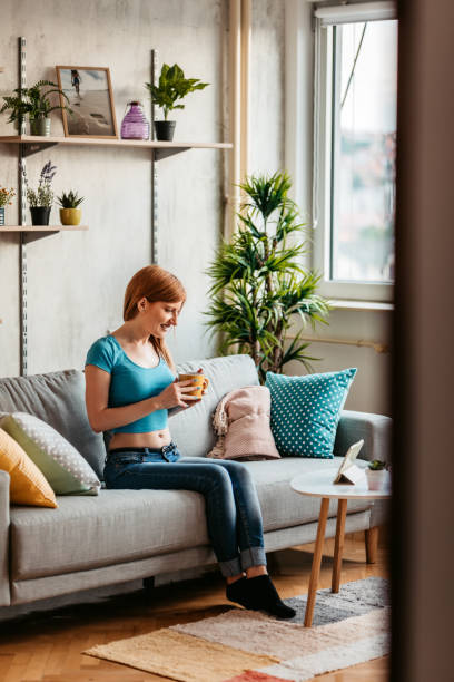 istock Woman drinking coffee with friends on video call 1326026765