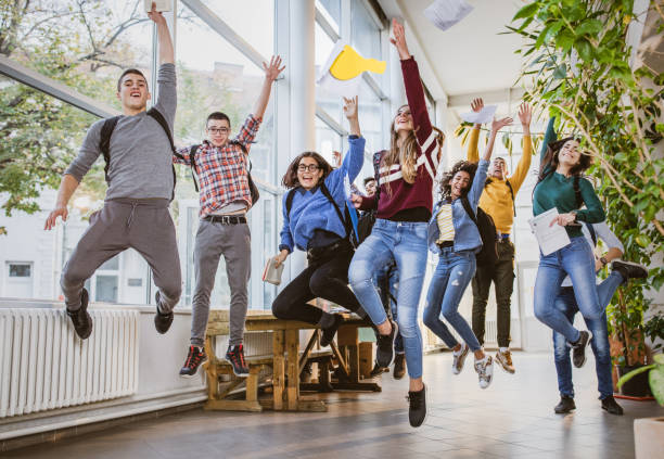 istock Playful high school students jumping in a school hallway. 1326029865