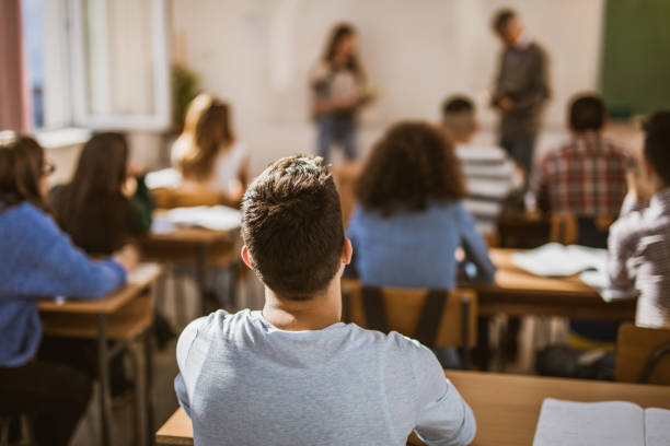 istock Back view of a male student on a class at high school. 1326029904