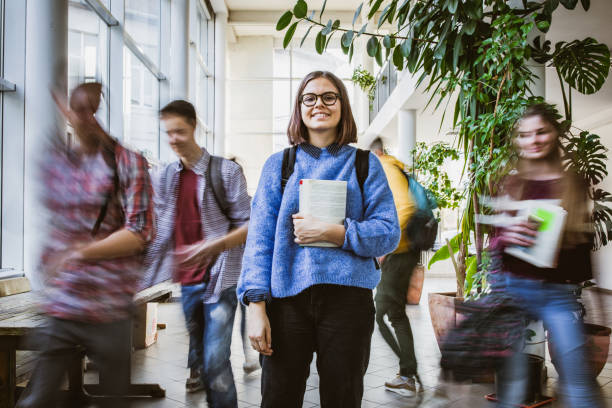 istock Happy teenage student among her classmate in blurred motion. 1326030519