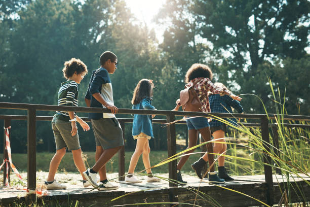 plan d’un groupe d’adolescents marchant sur un pont dans la nature au camp d’été - teenager team carefree relaxation photos et images de collection