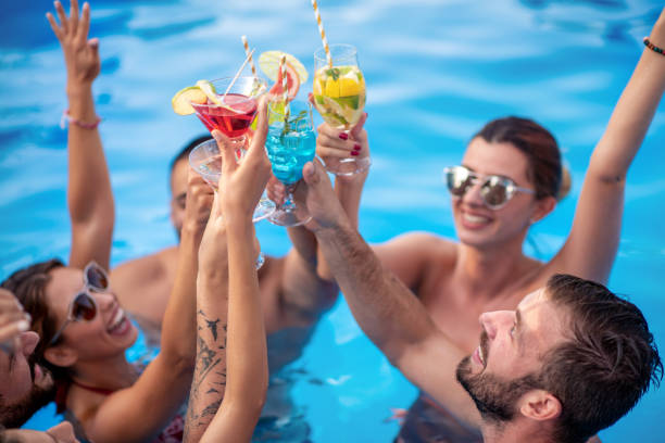 Group of friends having party in pool Group of friends having party in pool, drinking cocktails and enjoying together. pool party stock pictures, royalty-free photos & images