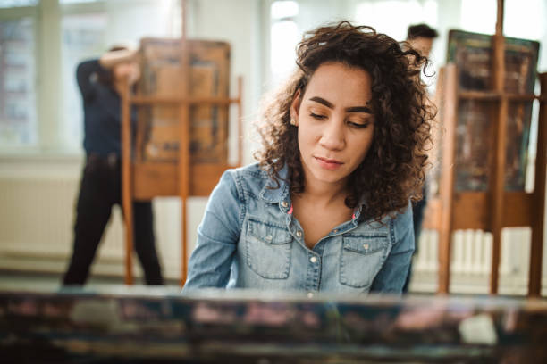 istock Female high school student making her painting on a class at art studio. 1326030896