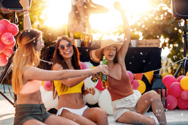女の子はスイミングプールでパーティーを持っています - drink alcohol summer celebration ストックフォトと画像