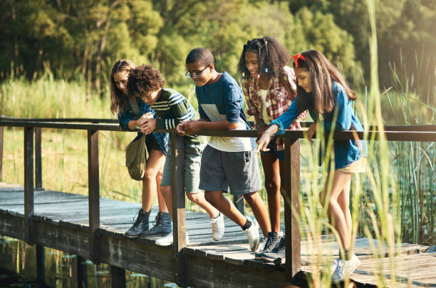 plan d’un groupe d’adolescents debout sur un pont dans la nature au camp d’été - teenager team carefree relaxation photos et images de collection