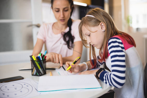 istock Elementary age girl trying to solve the task with her mother's assistance 1326033357
