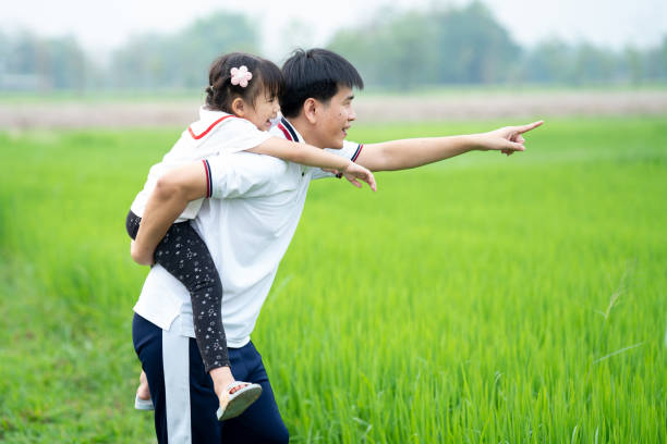 istock Asian Father and daughter walking in the green fields Happily and joyfully. 1326035178