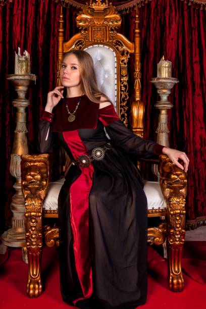 istock Medieval queen in historical attire on golden throne in castle 1326035263