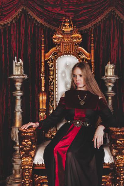 istock Medieval queen in historical attire on golden throne in castle 1326035284