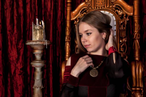 istock Medieval queen in historical attire on golden throne in castle 1326035285