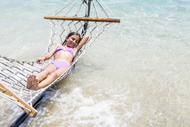 Beautiful girl relaxing on hammock at tropical beach