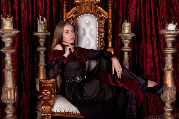 istock Medieval queen in historical attire on golden throne in castle 1326035304