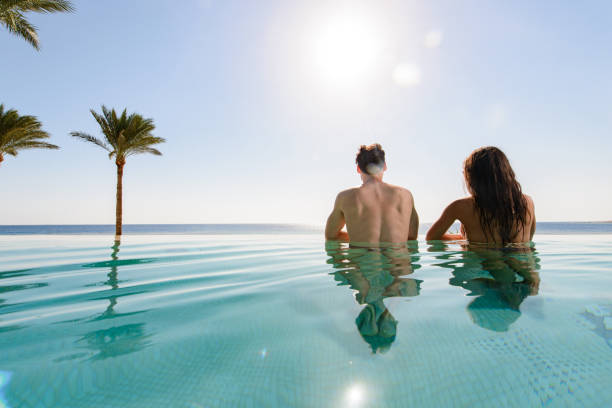 istock Back view of a couple in the infinity pool. 1326035497