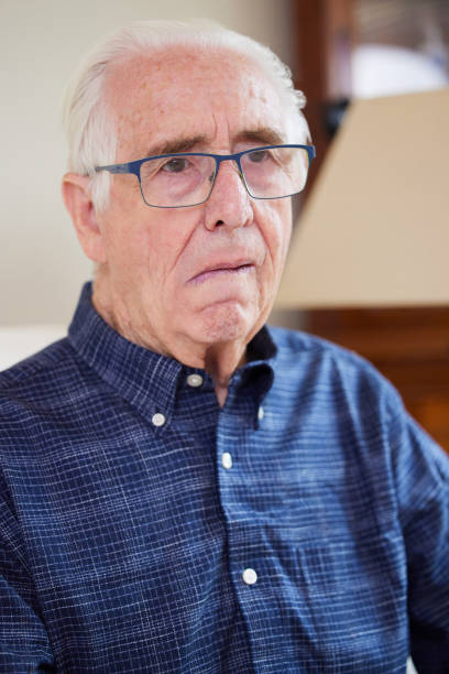 portrait d’un homme âgé à la maison souffrant d’un accident vasculaire cérébral montrant le côté du visage tombé - falling senior adult people one person photos et images de collection