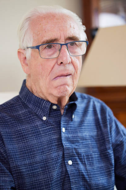 retrato de idoso em casa sofrendo de derrame mostrando lado caído do rosto - falling senior adult people one person - fotografias e filmes do acervo