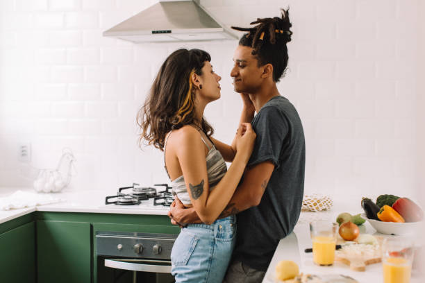 casal jovem bonito se unindo na cozinha - dating couple love latin american and hispanic ethnicity - fotografias e filmes do acervo