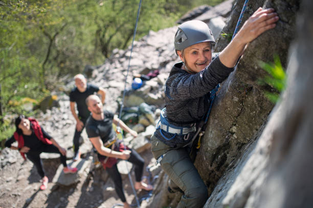 istock Group of seniors with instructor climbing rocks outdoors in nature, active lifestyle. 1326039346