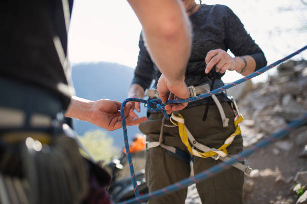 istock Unrecognizable instructor with senior woman getting ready for climbing rocks outdoors in nature, active lifestyle. 1326040228