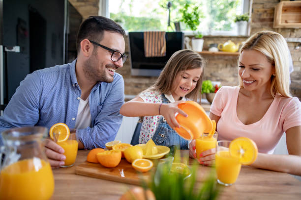 istock Happy family makes orange juice for breakfast in their kitchen 1326040394