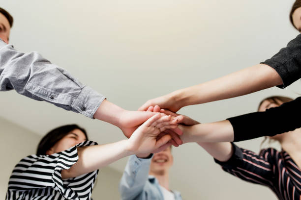 istock Group of people doing handshake and cross hands 1326042454