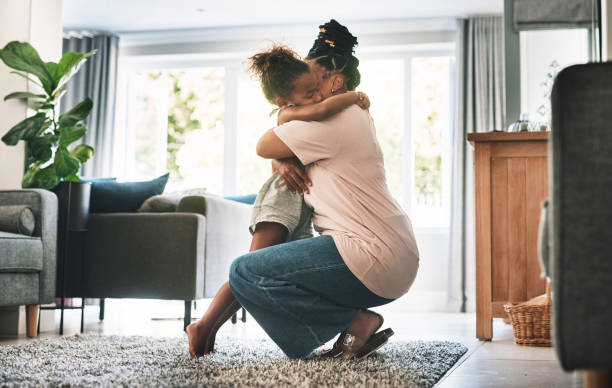 foto de una madre y un niño abrazándose en casa - abrazarse fotografías e imágenes de stock