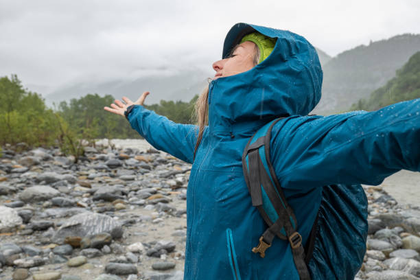 istock Hiker female under torrential rain arms open 1326048375