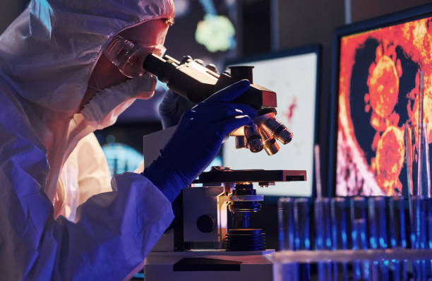 istock Scientist in white protective uniform near displays with data works with coronavirus and blood tubes in laboratory 1326048626