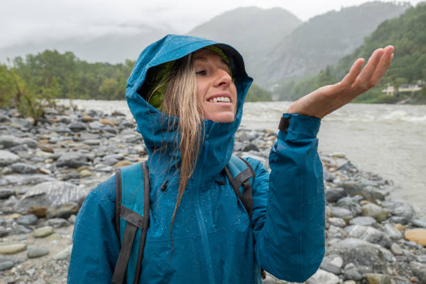 istock Hiker female under torrential rain, looks up, hands up 1326048832