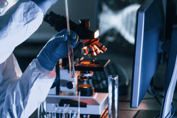 istock Scientist in white protective uniform works with coronavirus and blood tubes in laboratory 1326048996
