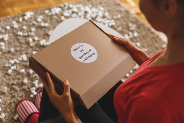 istock Woman opening a package she received in mail 1326050182