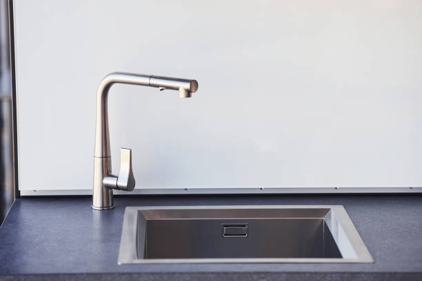 istock Silver colored tap indoors in the kitchen at daytime. Conception of modern decor 1326051957