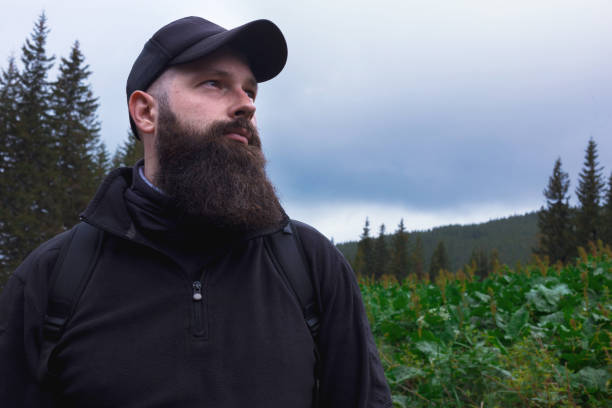 Handsome serious bearded hiker man enjoying mountain traveling location
