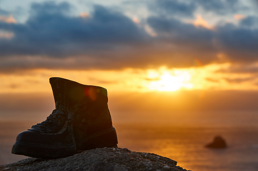 Finisterre Cape viewpoint at sunset with hiker boot mark. Pilgrimage