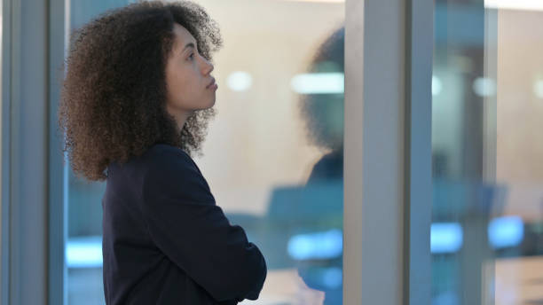 istock Young African Women Standing near Window and Thinking 1326056091