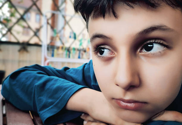 studio portrait of a 10 year old schoolboy on a yellow background