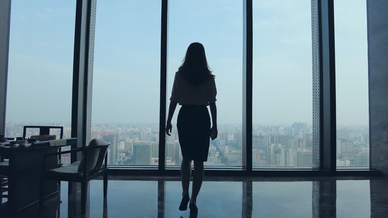 Business woman walking and looking through the window