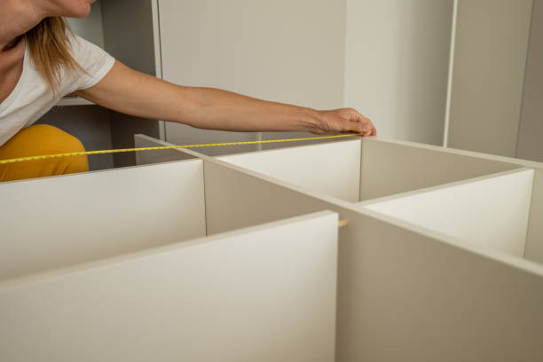 istock Young woman self assembling furniture at home 1326058536