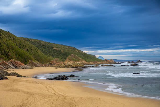 istock Beach and sea with mountains and cloudy skies 1326059966