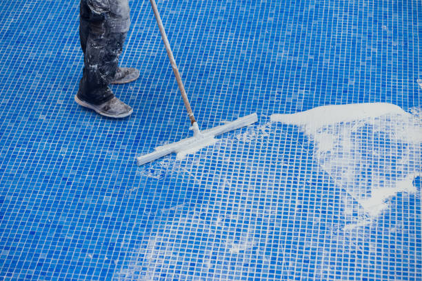 istock Covering seames on the tile in the pool. Pool repairing work 1326060417