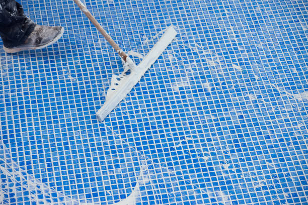 istock Covering seames on the tile in the pool. Pool repairing work 1326060419
