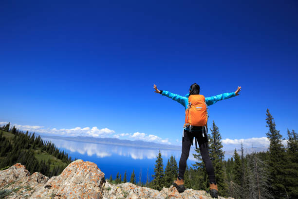 istock Successful woman backpacker hiking on forest mountain peak 1326060609