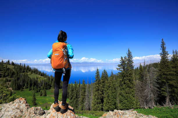istock Successful woman backpacker hiking on forest mountain peak 1326060675