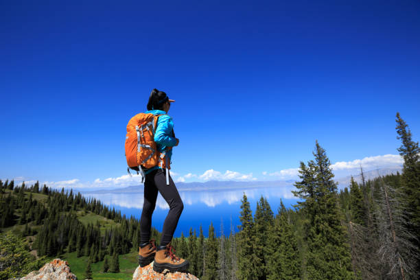 istock Successful woman backpacker hiking on forest mountain peak 1326060738