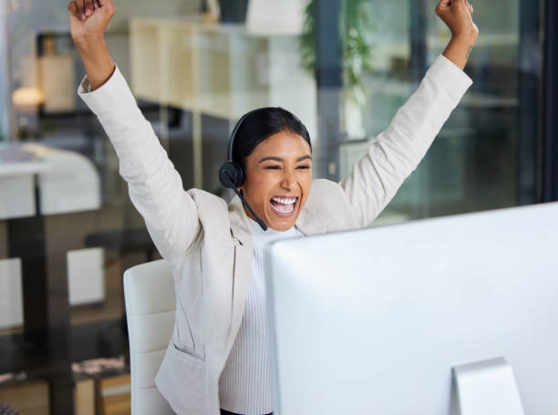 shot of a young woman working in a call center caught in a moment of victory in a modern office - excitement business person ecstatic passion imagens e fotografias de stock